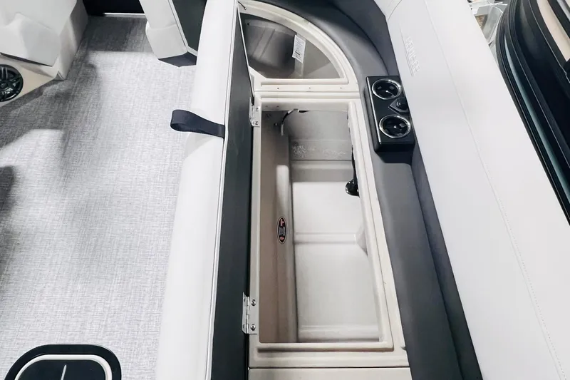 Slide: The Image of 2025 Harris Cruiser 230 boat interior with open storage compartment and cup holders. - 40