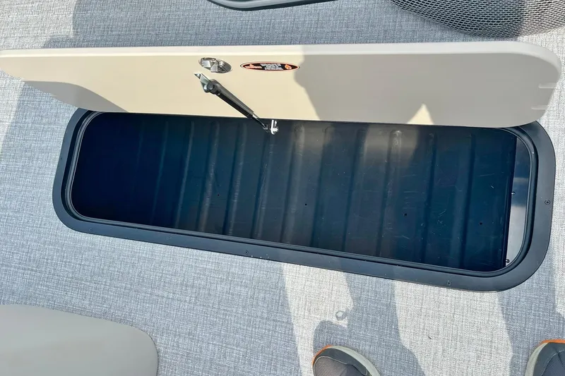 Slide: The Image of Open storage compartment on 2025 Harris Cruiser 230 boat deck. - 43