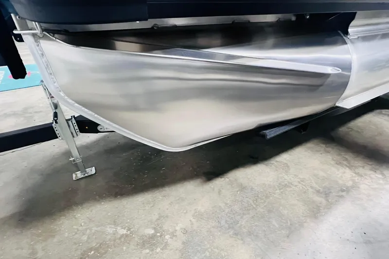 Slide: The Image of 2025 Harris Cruiser 230 pontoon boat hull on a trailer in a garage. - 45