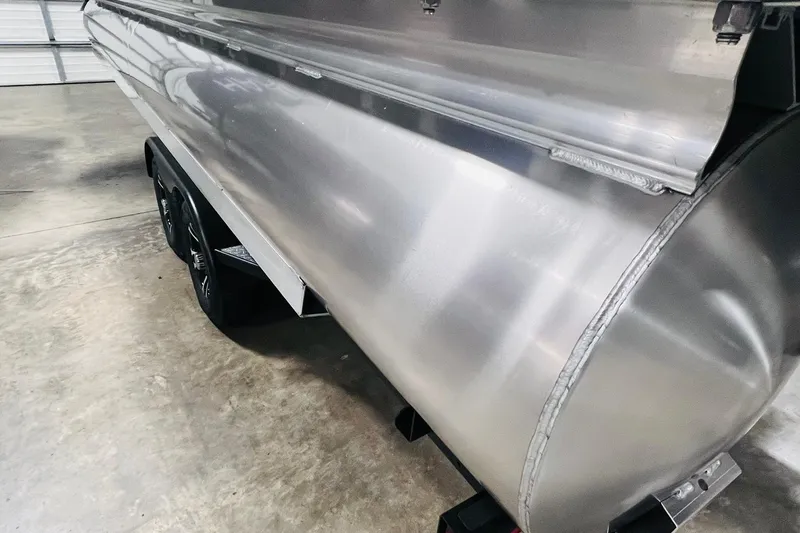 Slide: The Image of 2025 Harris Cruiser 230 pontoon boat in a garage, showcasing sleek aluminum design. - 49