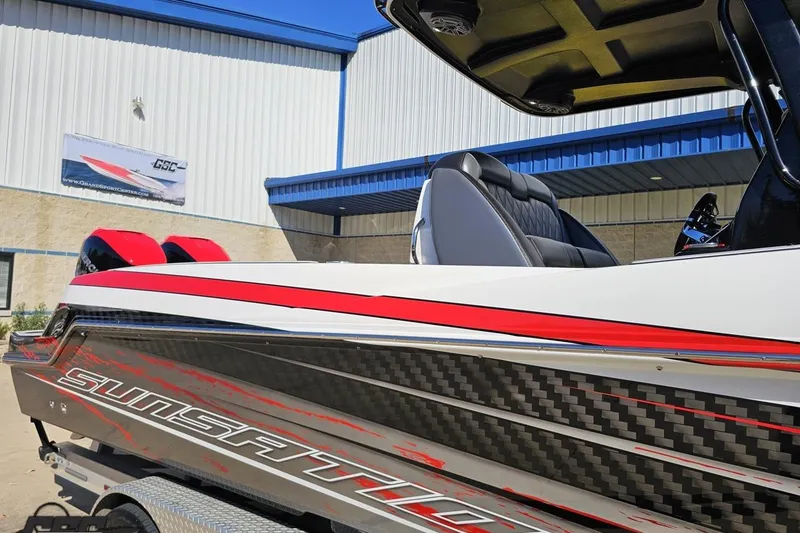 Slide: The Image of 2020 Sunsation 32 CCX boat with sleek design and red accents, parked outside a building. - 19