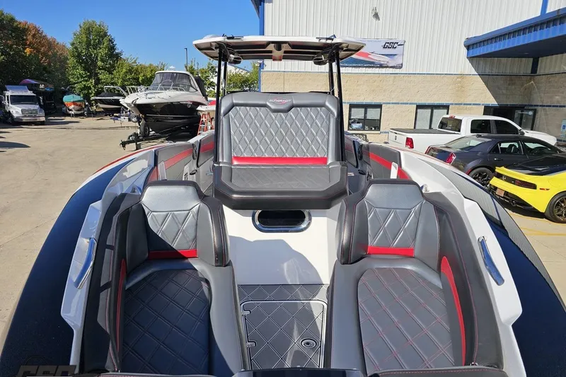 Slide: The Image of 2020 Sunsation 32 CCX boat interior with diamond-stitched seating, parked outdoors. - 24