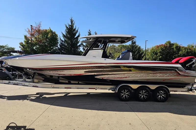 Slide: The Image of 2020 Sunsation 32 CCX boat on trailer, sleek design, vibrant graphics, sunny day. - 29