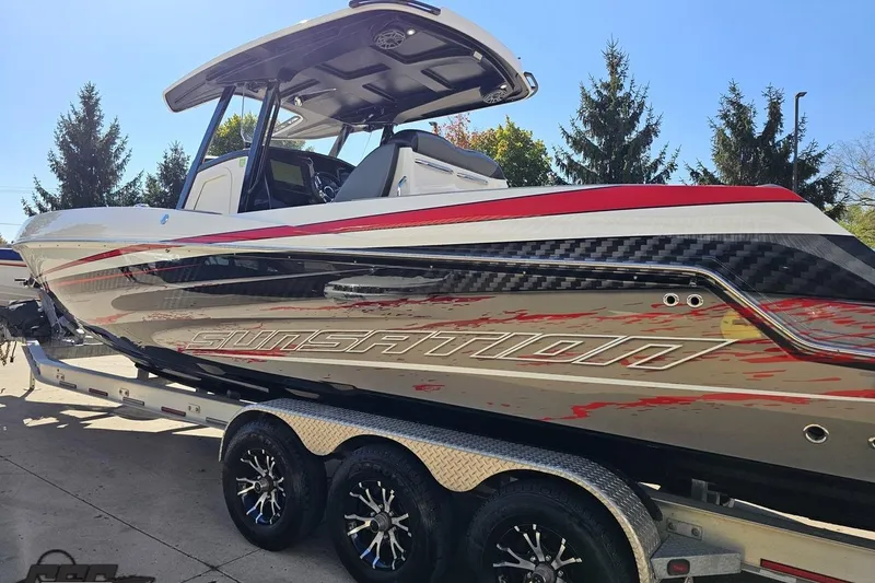Slide: The Image of 2020 Sunsation 32 CCX boat with sleek design on a trailer, featuring red and black accents. - 34