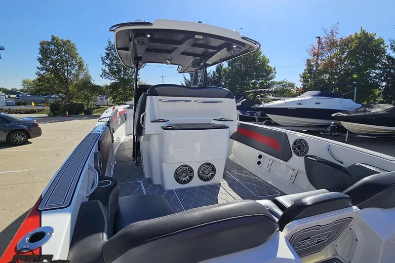Slide: The Image of 2020 Sunsation 32 CCX boat interior with seating and speakers, parked outdoors. - 53