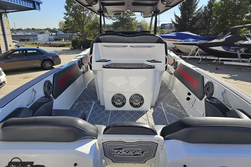 Slide: The Image of 2020 Sunsation 32 CCX boat interior with seating and speakers, parked outdoors. - 54
