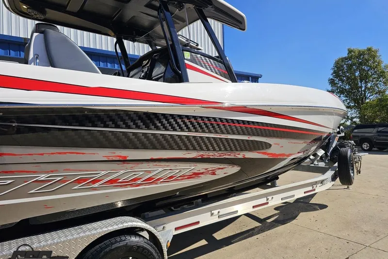Slide: The Image of 2020 Sunsation 32 CCX boat with sleek red and black design on a trailer. - 8
