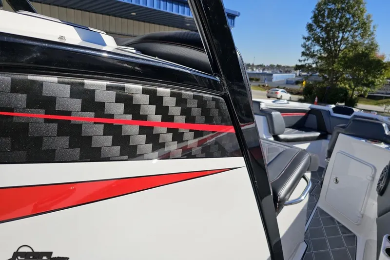 Slide: The Image of 2020 Sunsation 32 CCX boat with carbon fiber and red accents, docked outdoors. - 88