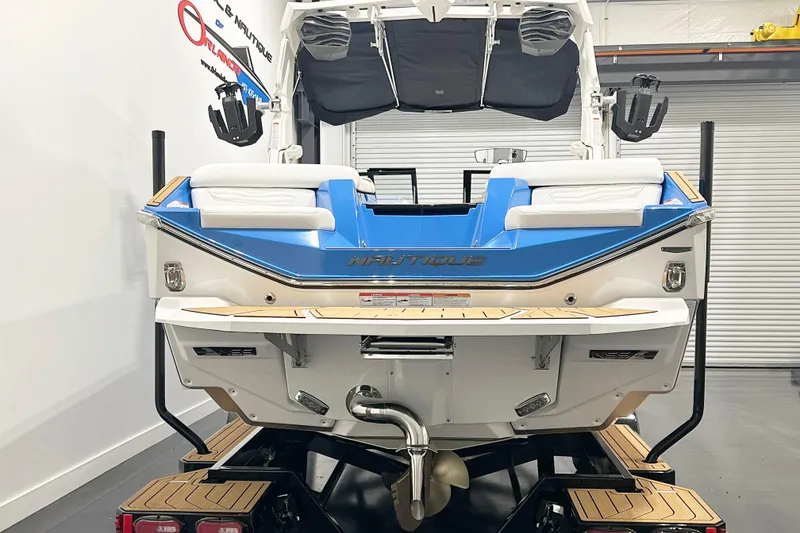 Slide: The Image of 2025 Nautique Super Air Nautique G23 boat, rear view in showroom setting. - 4