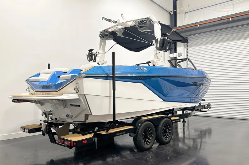 Slide: The Image of 2025 Nautique Super Air Nautique G23 boat in showroom, blue and white design on trailer. - 5