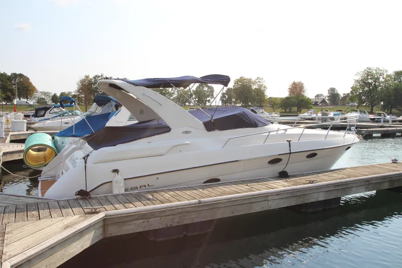 The Image of 1999 Regal Commodore 322 boat docked at marina with blue canopy. - 0