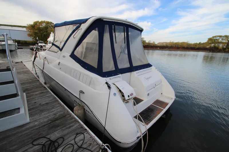 Slide: The Image of 1999 Regal Commodore 322 boat docked at a marina, featuring a blue canopy. - 2