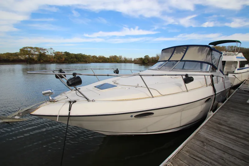 Slide: The Image of 1999 Regal Commodore 322 boat docked on a calm lake under a blue sky. - 3