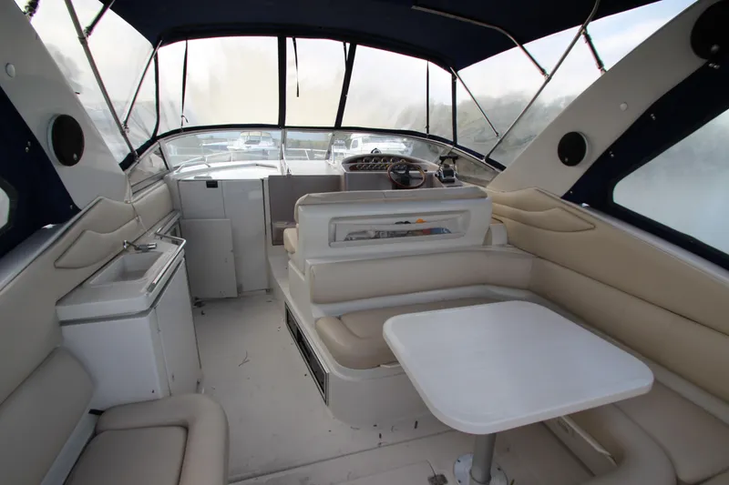 Slide: The Image of Interior of 1999 Regal Commodore 322 boat with seating, table, and helm. - 4