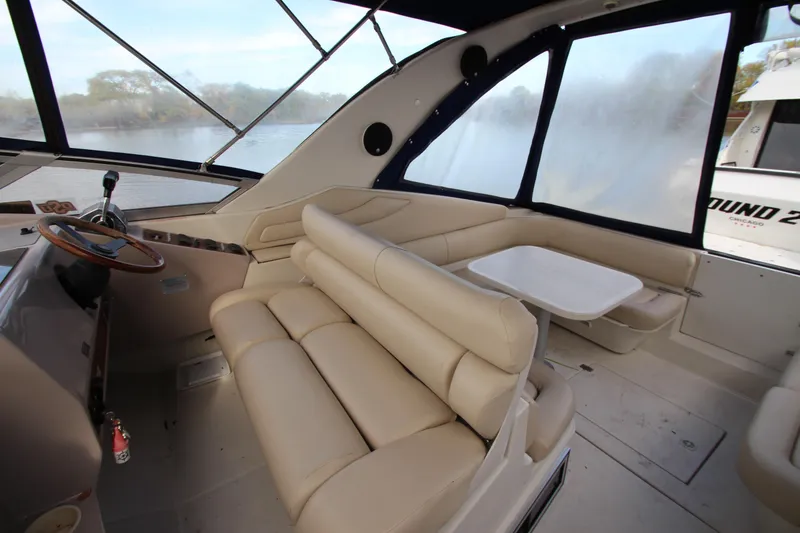 Slide: The Image of 1999 Regal Commodore 322 boat interior with beige seating and steering wheel. - 6