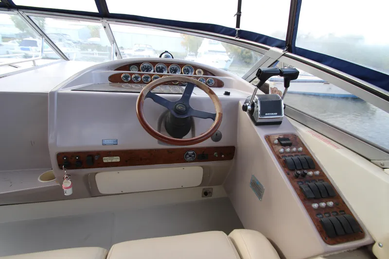 Slide: The Image of 1999 Regal Commodore 322 boat helm with wood accents and control panel. - 8