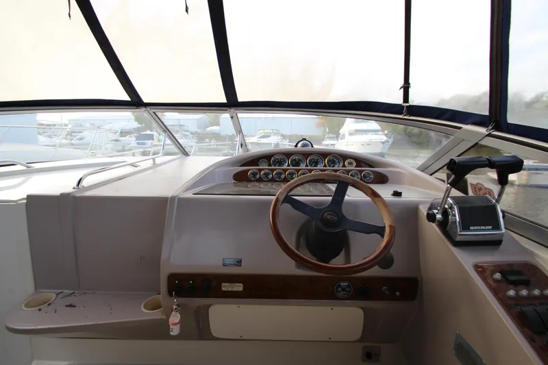 Slide: The Image of 1999 Regal Commodore 322 boat helm with steering wheel and control panel. - 9