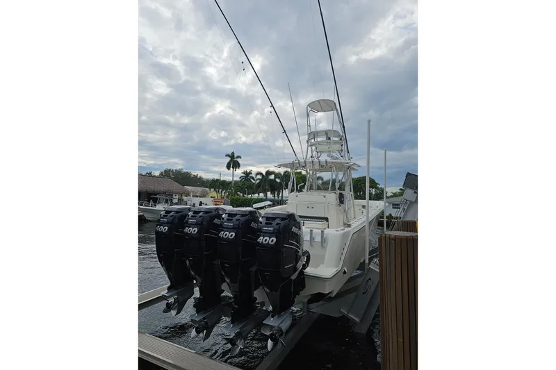 Slide: The Image of 2019 SeaVee 390Z boat with four powerful outboard motors docked under cloudy skies. - 9