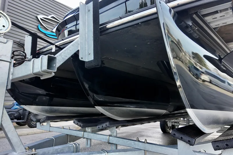 Slide: The Image of 2026 Sylvan M-5 CLZ DC pontoon boat on trailer, sleek black design. - 22