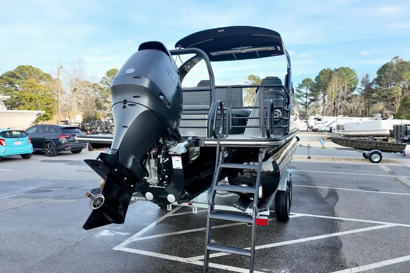 Slide: The Image of 2026 Sylvan M-5 CLZ DC boat with outboard motor in a parking lot. - 24