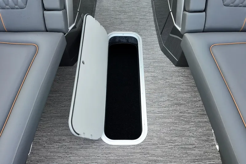 Slide: The Image of 2026 Sylvan M-5 CLZ DC boat interior with open storage compartment between seats. - 6