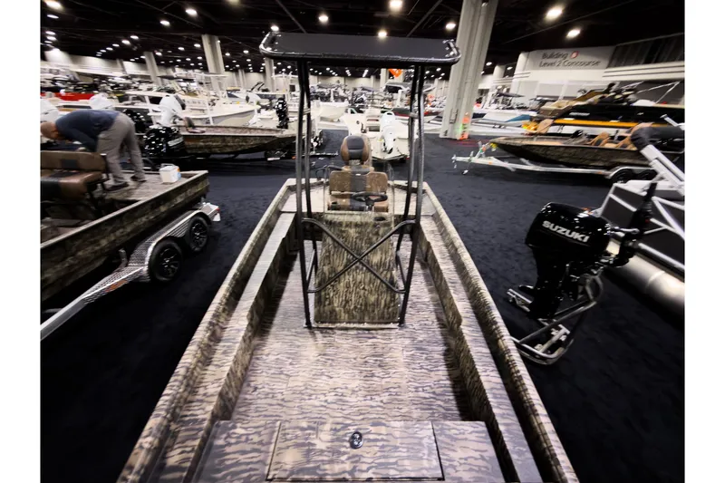 Slide: The Image of 2026 Excel 216 Stalker Center Console boat displayed at an indoor boat show. - 13