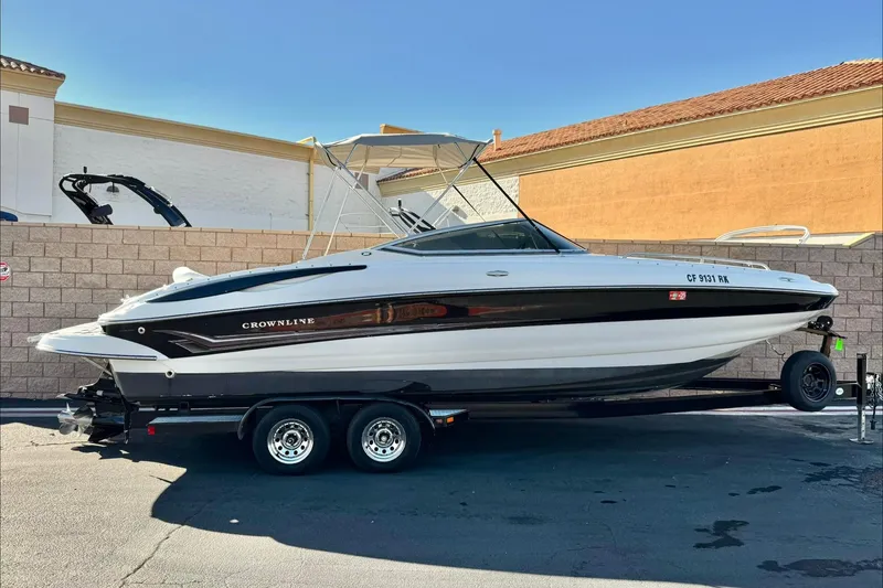 The Image of 2006 Crownline 260 EX boat on trailer, parked outdoors, side view. - 0