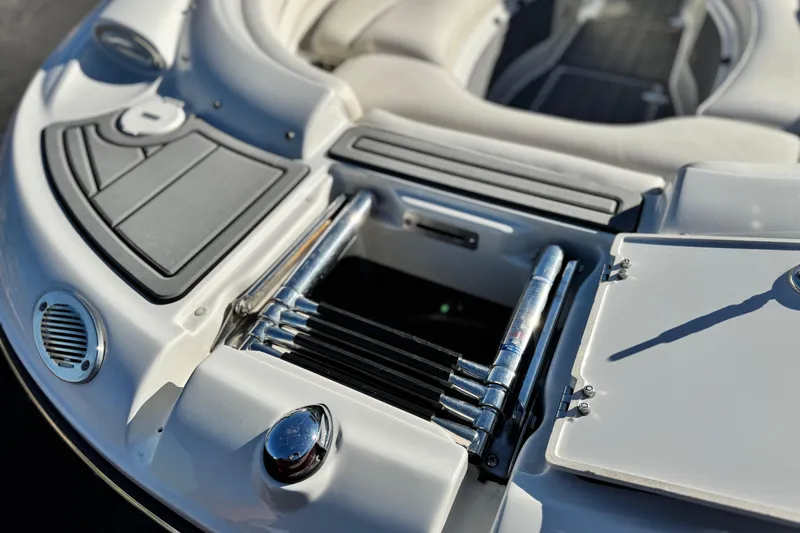 Slide: The Image of 2006 Crownline 260 EX boat with open storage compartment and ladder. - 10
