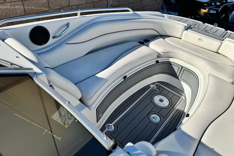 Slide: The Image of Luxurious seating area on a 2006 Crownline 260 EX boat, featuring sleek white upholstery. - 13