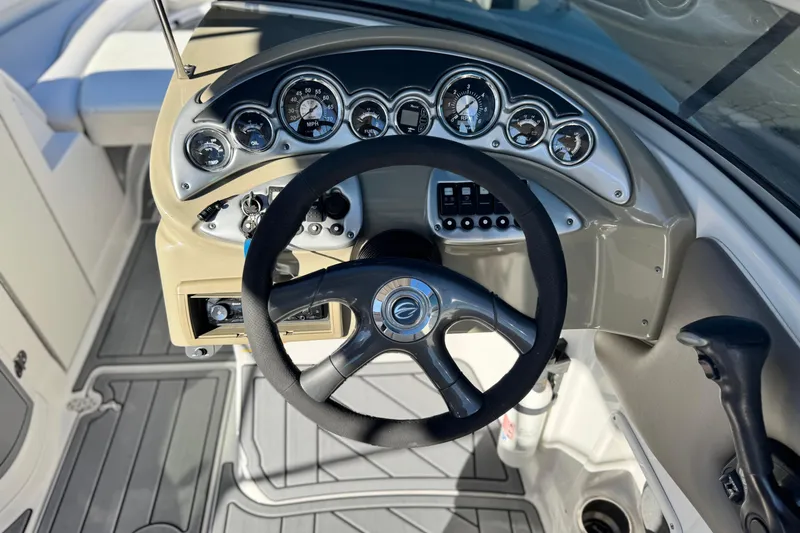 Slide: The Image of Steering wheel and dashboard of 2006 Crownline 260 EX boat, featuring gauges and controls. - 31