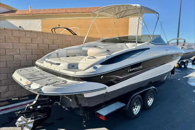 Slide: The Image of 2006 Crownline 260 EX boat on trailer, featuring sleek design and spacious seating. - 5