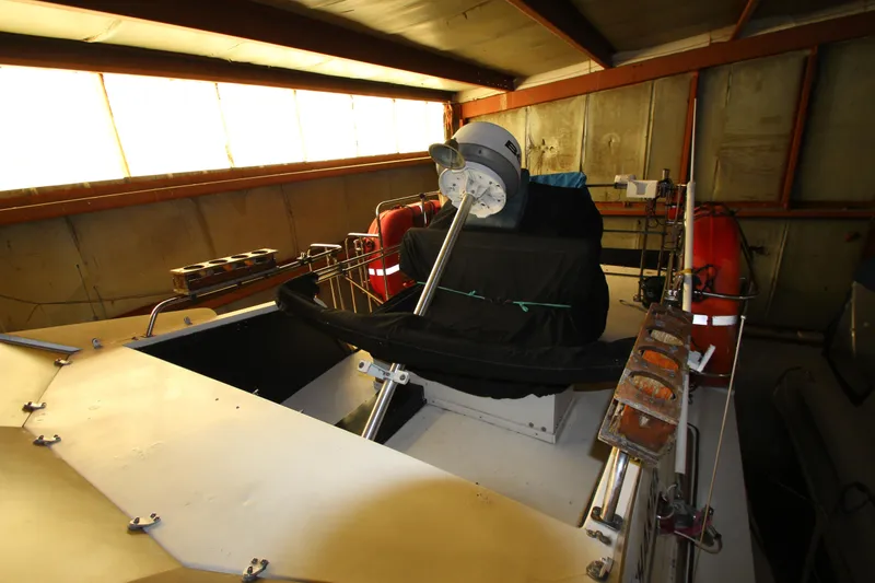 Slide: The Image of 1980 Delta Boatworks 34 Offshore in storage, featuring radar equipment and life preservers. - 13