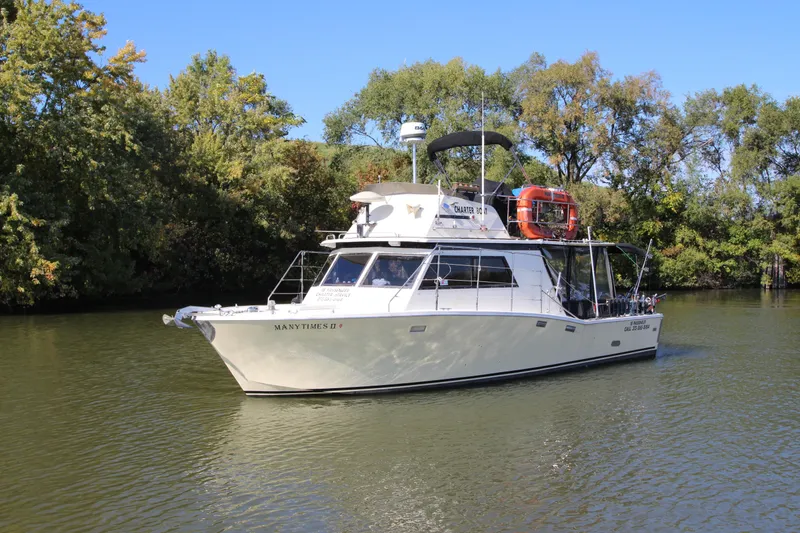 Slide: The Image of 1980 Delta Boatworks 34 Offshore cruising on a calm river, surrounded by lush trees. - 2