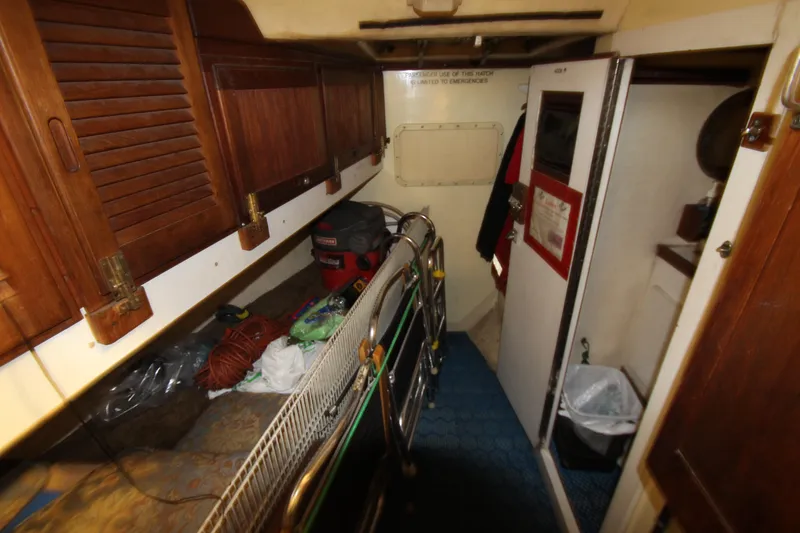 Slide: The Image of Interior of 1980 Delta Boatworks 34 Offshore, featuring wooden cabinets and storage area. - 27