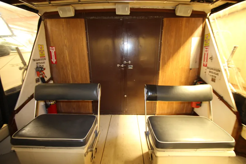 Slide: The Image of Interior of 1980 Delta Boatworks 34 Offshore with two black cushioned seats. - 8