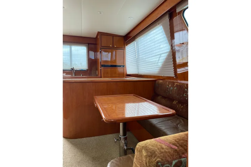 Slide: The Image of Interior of 2012 Mikelson 43 Sportfisher yacht with wooden table and seating area. - 30