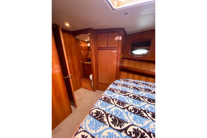 Slide: The Image of Interior of 2012 Mikelson 43 Sportfisher with wood finish and patterned bedding. - 34
