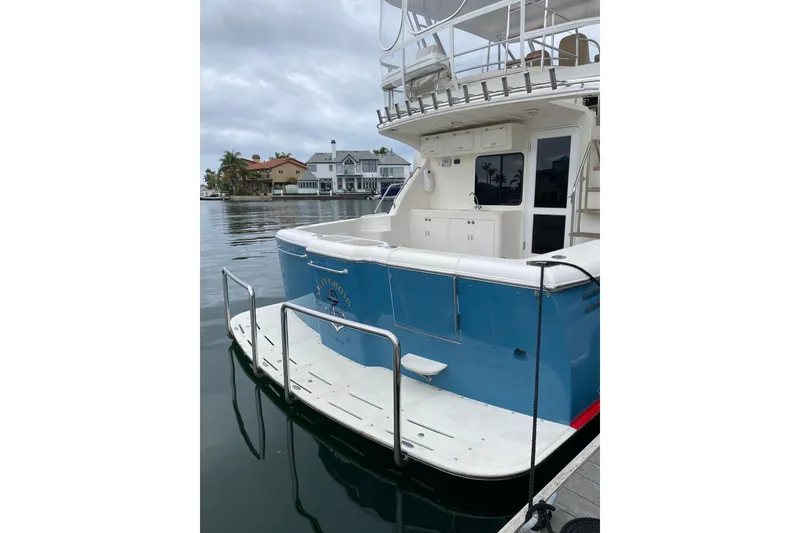 Slide: The Image of 2012 Mikelson 43 Sportfisher docked, showcasing spacious deck and sleek design. - 4