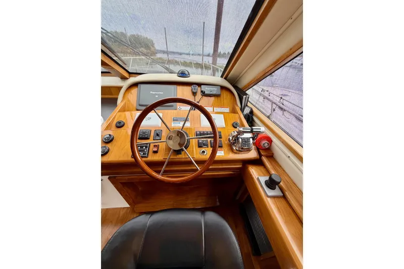 Slide: The Image of 2009 Navigator California 50 Veneti yacht helm with wooden steering wheel and navigation controls. - 8