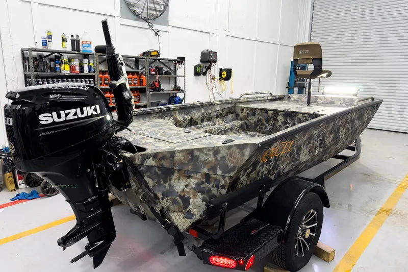 Slide: The Image of 2026 Excel Eclipse boat with Suzuki engine in a workshop setting. - 13