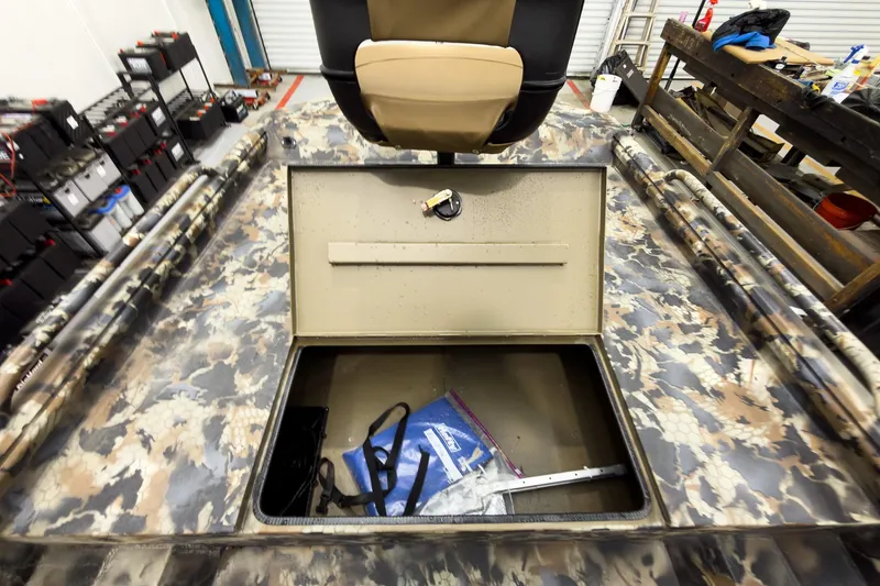 Slide: The Image of Camouflage-patterned boat interior with open storage compartment, featuring a seat and various equipment. - 22
