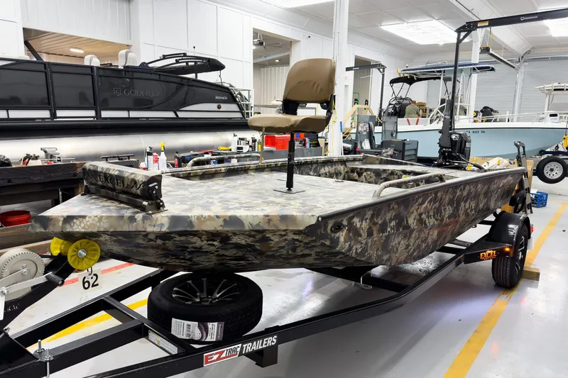 Slide: The Image of Camouflage-patterned 2026 Excel Eclipse boat on trailer in showroom. - 6