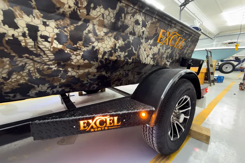 Slide: The Image of Camouflage-patterned Excel Eclipse 2026 boat trailer with illuminated logo in a workshop setting. - 7