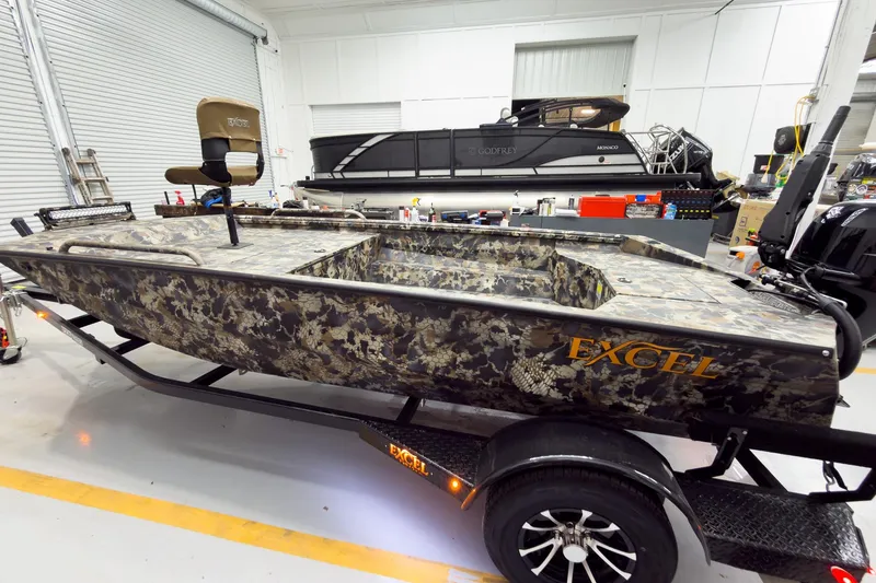 Slide: The Image of 2026 Excel Eclipse boat with camouflage design in a garage setting. - 8