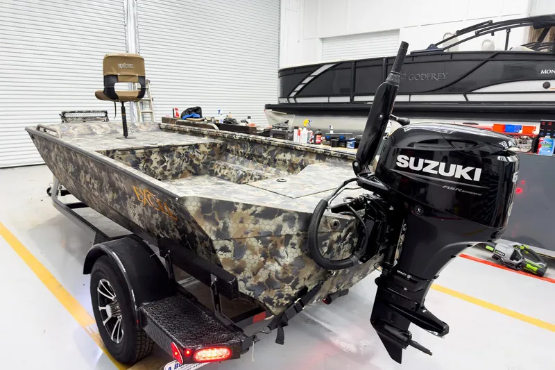 Slide: The Image of 2026 Excel Eclipse boat with Suzuki outboard motor in a garage setting. - 9