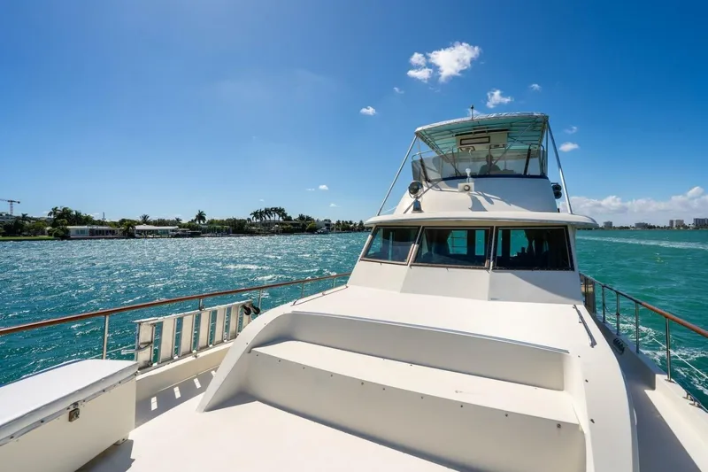 Slide: The Image of 1978 Hatteras 53 Yacht Fisherman cruising on a sunny day with clear blue skies. - 14