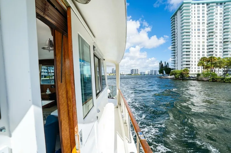 Slide: The Image of 1978 Hatteras 53 Yacht Fisherman cruising near waterfront high-rise buildings. - 29