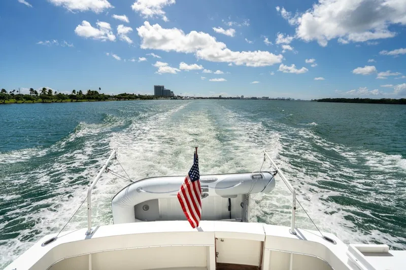 Slide: The Image of 1978 Hatteras 53 Yacht Fisherman cruising on open water under a clear blue sky. - 30