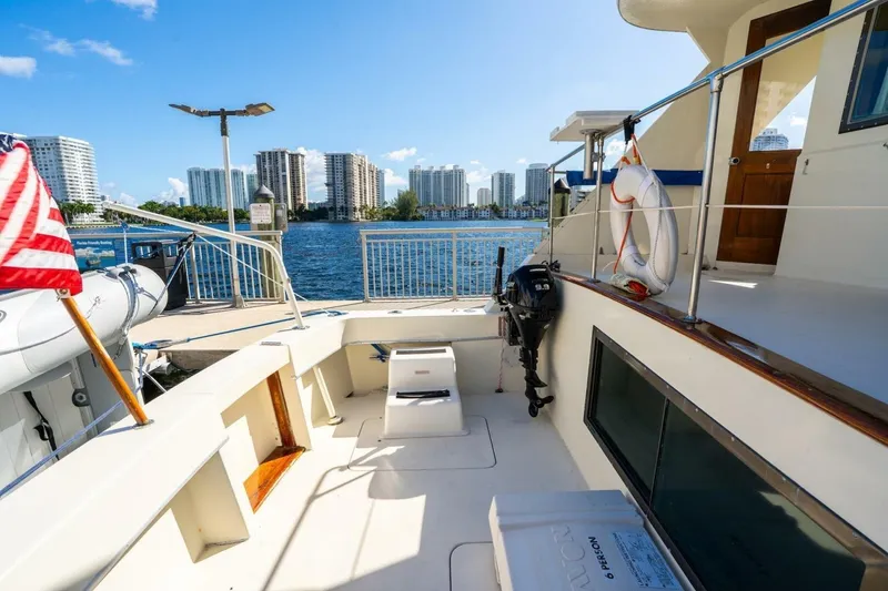 Slide: The Image of 1978 Hatteras 53 Yacht Fisherman docked, with city skyline and American flag. - 35