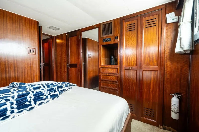 Slide: The Image of 1978 Hatteras 53 Yacht Fisherman cabin with wood paneling and cozy bedding. - 58